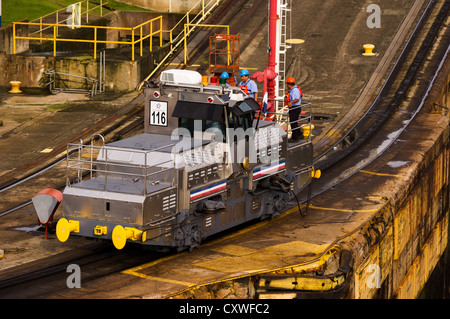 Panama Panama Canal Electric mules or railroad tugs used to guide ships through the locks of the Panama Canal.  These tugs keep the ships aligned by using steel cables to shift the ships within the lock. Stock Photo