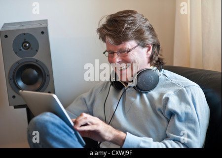 Mature man at home using his iPad tablet computer in contemporary living room Stock Photo