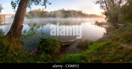 Autumn fog over the river, the sun shines the wood on shore, outdoors Stock Photo