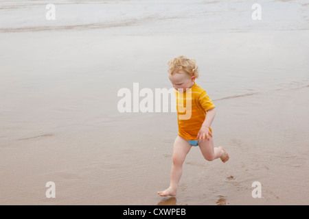 Boy running in waves on beach