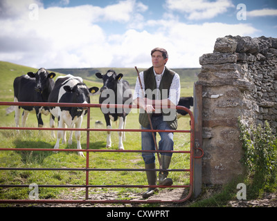 Farmer standing in field with cows