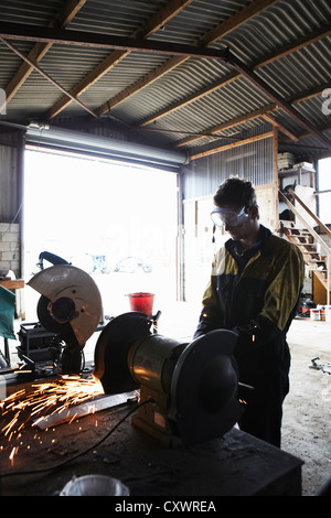 Metal worker using grinder in shop Stock Photo