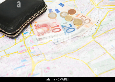 Euro notes and coins on city map Stock Photo