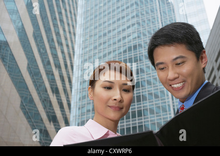 Business people reading on city street Stock Photo