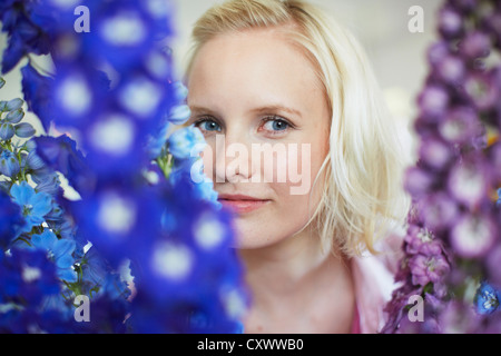 Close up of woman with tall flowers Stock Photo