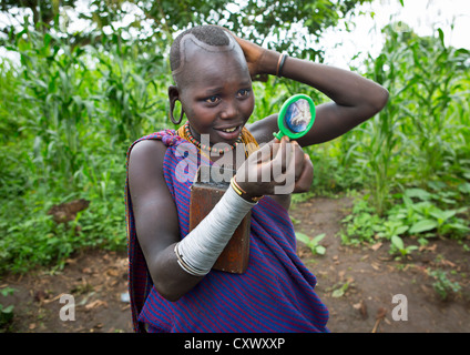 Suri Tribe Girl Looking At Her Hair, Kibish, Omo Valley, Ethiopia Stock Photo