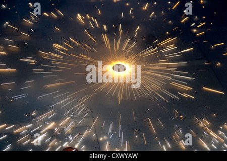 Large number of sparks from a spinning firecracker during Diwali celebrations. It looks beautiful, and emits lots of pollution Stock Photo