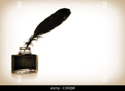 Feather and ink bottle in sepia colors Stock Photo