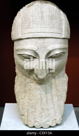 Head from a colossal statue of a bearded worshipper with helmet. Limestone. Made in Cyprus. 570-550 BC. From Byblos. Stock Photo