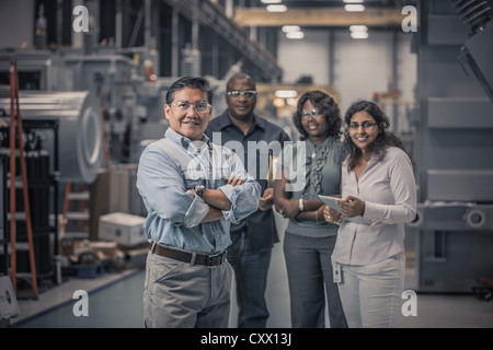 Workers standing together in factory Stock Photo