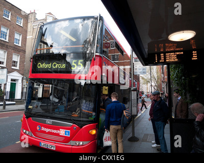 People boarding a 55 red double decker bus destined for Oxford Circus London England UK KATHY DEWITT Stock Photo