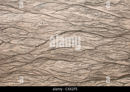 Beach patterns caused by the retreating tide leaving rivulets and meanders in the sand, Stock Photo
