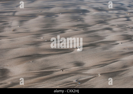 Beach patterns caused by the retreating tide leaving rivulets and meanders in the sand, Stock Photo