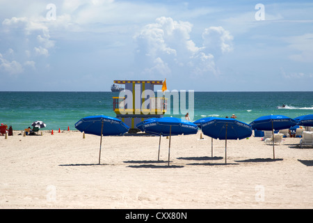 umbrellas and sunshades with lifeguard tower looking out to sea miami south beach florida usa Stock Photo