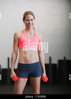 Caucasian woman using dumbbells Stock Photo