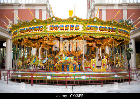 traditional merry go round or fun fair carousel with horses Stock Photo