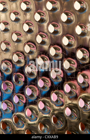 Dramatic macro view of the holes in an old, scratched kitchen cheese grater Stock Photo
