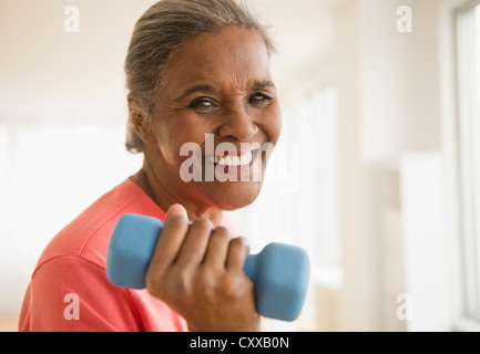 African American woman lifting dumbbells Stock Photo