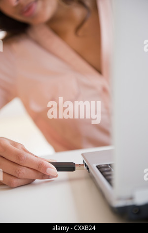 Cape Verdean woman using USB device Stock Photo