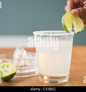 Cape Verdean woman putting lime on cocktail Stock Photo