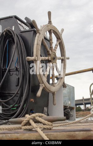 Antique Wooden Ship Steering Wheel on a Docked Old Historic Ship Stock Photo