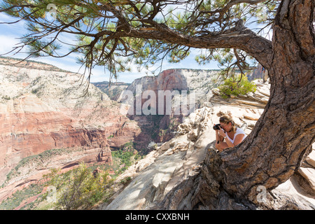 Woman photographing a scenery of a Zion Canyon from a top of Angels Landing at Zion National Park Stock Photo