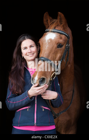 Portrait of a young woman with an Austrian warmblood horse, gelding, old horse, chestnut colour, North Tyrol, Austria, Europe Stock Photo