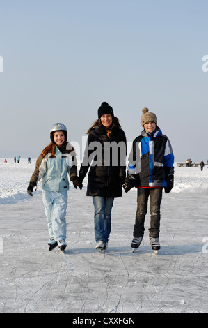 Mother with her children ice skating near St. Heinrich, Lake Starnberg, Five Lakes region, Upper Bavaria, Bavaria Stock Photo