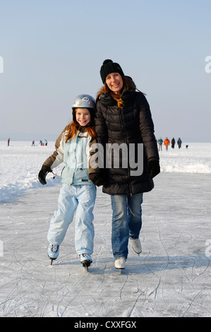 Mother and daughter ice skating near St. Heinrich, Lake Starnberg, Five Lakes region, Upper Bavaria, Bavaria Stock Photo