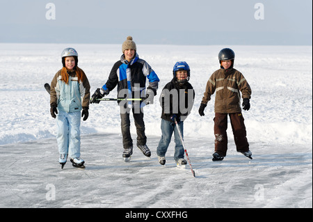 Children playing ice hockey, near St. Heinrich, Lake Starnberg, Five Lakes region, Upper Bavaria, Bavaria Stock Photo