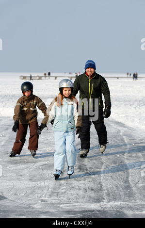 Familiy ice skating near St. Heinrich, Lake Starnberg, Five Lakes region, Upper Bavaria, Bavaria Stock Photo