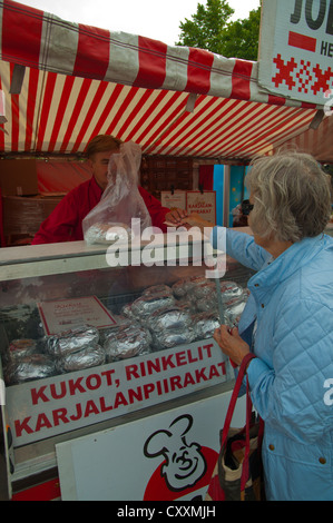 Woman buying Kalakukko the rye breaded seafood dish from eastern Finland at an autumn seafood festival Pori western Finland Stock Photo