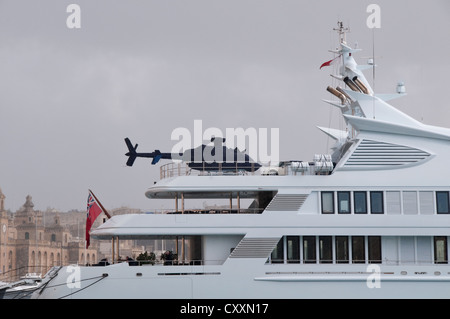 A helicopter and Mini on the deck of a luxury yacht moored in Vittoriosa Marina, Malta Stock Photo