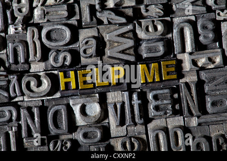 Old lead letters forming the words 'HELP ME' Stock Photo