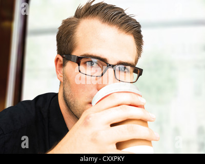 Young businessman wearing glasses, holding a cup of coffee Stock Photo