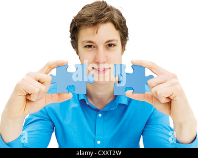 Young man holding pieces of a puzzle Stock Photo