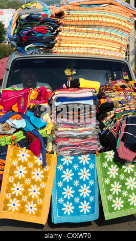 Traveling salesmen in their overloaded mobile shop selling clothes and household textile items on the road in India Stock Photo