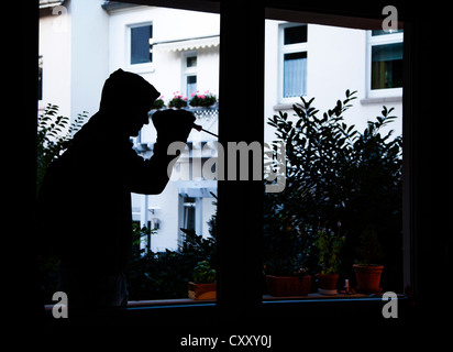 Burglar breaks into an apartment. Symbol image. Stock Photo