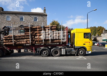 Fawcetts of Teeside transporting felled timber, lumber, logging trucks, wooden, pile, forestry; Leyburn, Wensleydale, North Yorkshire Dales, UK Stock Photo