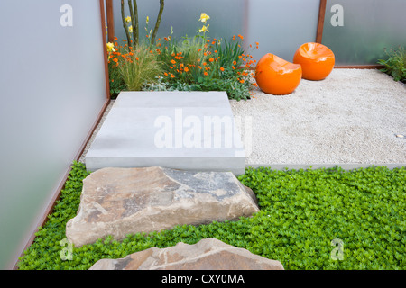 modern contemporary English small courtyard gravel garden with stone boulders and modern seating area patio Chelsea flower show UK Stock Photo