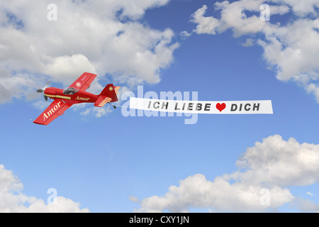 Plane in the sky pulling a banner with the message Ich liebe dich, German for I love you, illustration Stock Photo