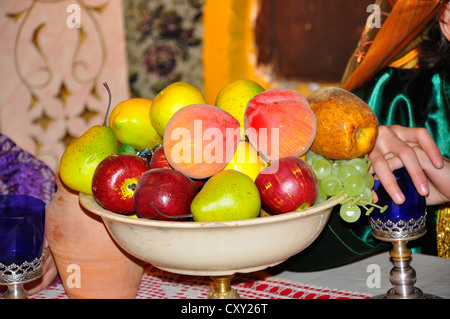 bowl full of fruits lying on the table, healthy breakfast apples, pears, peaches, grapes Stock Photo