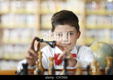 Boy considering a move while playing chess Stock Photo