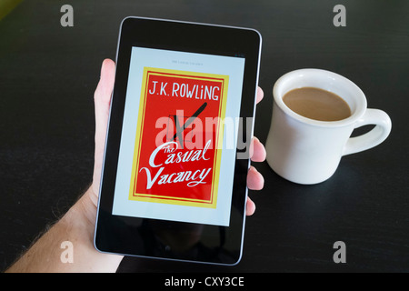Man reading The Casual Vacancy by JK Rowling e-book on Google Nexus 7 tablet computer running android operating system Stock Photo