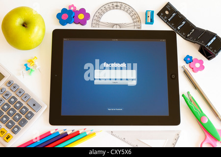 Facebook on Ipad 3 with school accesories on white background Stock Photo