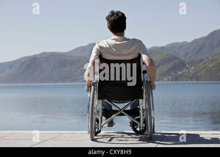 Caucasian man in wheelchair sitting on dock Stock Photo