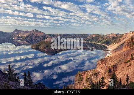 Spectacular morning cloud pattern develops over Wizard Island and the caldera rim of Oregon’s Crater Lake National Park. Stock Photo
