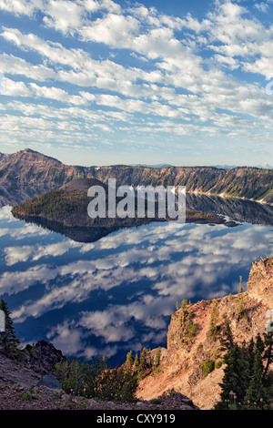 Spectacular morning cloud pattern develops over Wizard Island and the caldera rim of Oregon’s Crater Lake National Park. Stock Photo