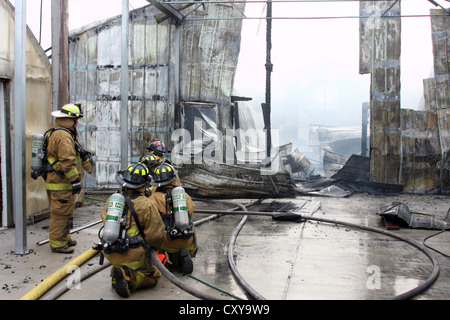 Firefighters on a scene of a fire roof collapse Stock Photo