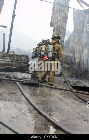 Firefighters on the scene of a fire in an industrial building Stock Photo